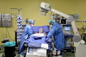 Nhân viên y tế điều trị cho một bệnh nhân Covid-19 trong phòng chăm sóc tích cực tại một bệnh viện ở Milan, Italy, hôm 27/3. Ảnh: Reuters. 