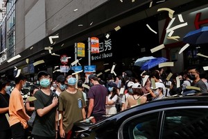 Người biểu tình tung tiền âm phủ trong cuộc tuần hành phản đối luật an ninh hôm 1/7. Ảnh: Reuters.