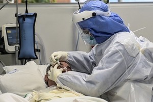 Y tá nhỏ thuốc mắt cho bệnh nhân Covid-19 tại Colombia ngày 8/7. Ảnh: AFP.