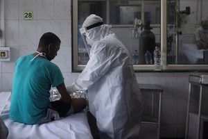 Nhân viên y tế chăm sóc cho bệnh nhân nhiễm nCoV tại một bệnh viện ở thủ đô New Delhi, Ấn Độ, ngày 17/7. Ảnh: Reuters.