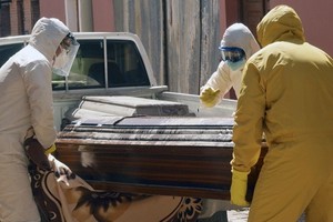 Nhân viên y tế di chuyển quan tài nạn nhân Covid-19 từ một viện dưỡng lão ở Cochabamba, Bolivia hôm 20/7. Ảnh: AFP.