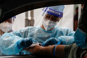 Nhân viên y tế lấy mẫu máu tại một điểm xét nghiệm nCoV trên ôtô ở thủ đô Manila, Philippines, ngày 15/7. Ảnh: Reuters.