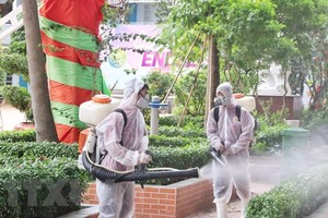 Nhân viên y tế phun thuốc khử khuẩn khu vực sân trường, cây cối, đảm bảo vệ sinh cho khuôn viên trường.