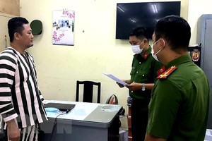 Cơ quan Cảnh sát điều tra Công an Thành phố Hồ Chí Minh tống đạt các quyết định khởi tố và lệnh bắt tạm giam đối với Ngô Minh Danh. (Nguồn: TTXVN).