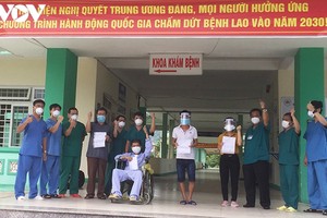 Bệnh nhân 582 ngồi xe lăn cùng 3 bệnh nhân khác bày tỏ niềm vui chiến thắng Covid-19 cùng các bác sĩ.