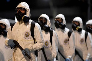 Binh sĩ Brazil chuẩn bị phun khử khuẩn ở bang Minas Gerais hôm 18/8. Ảnh: AFP.