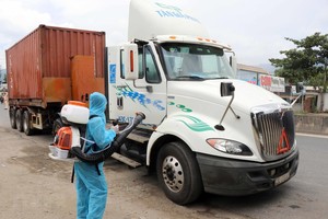 Nhân viên y tế phun thuốc khử khuẩn đối với những xe chở hàng hóa đến từ vùng dịch bệnh tại chốt kiểm soát dịch bệnh số 6 của Thừa Thiên-Huế. (Ảnh: Đỗ Trưởng/TTXVN).
