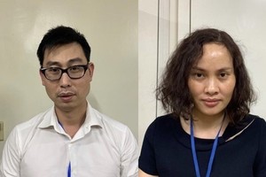 Bị can Phạm Đức Tuấn (nam áo trắng) và bị can Ngô Thị Thu Huyền (nữ áo xanh đen). (Nguồn: Bộ Công an).