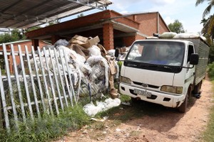 Chất thải công nghiệp được đổ trái quy định tại văn phòng Chi nhánh Công ty TNHH một thành viên thu gom rác Hiền Lương. (Ảnh: Lê Đức Hoảnh/TTXVN).