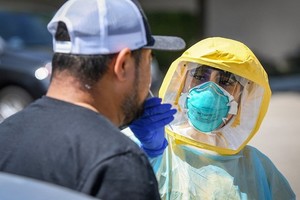 Nhân viên y tế tại hạt Fresno, bang California, Mỹ, lấy mẫu xét nghiệm nCoV cho một người dân ngày 8/8. Ảnh: Reuters.