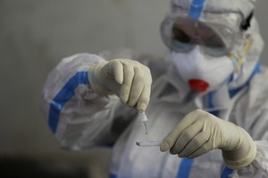 Nhân viên y tế tại một điểm xét nghiệm nCoV ở Jammu, Ấn Độ, hôm 7/9. Ảnh: AP.