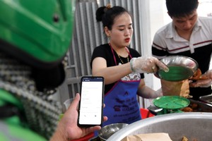 Mobile Money sẽ cung cấp thêm một hình thức thanh toán không tiền mặt phù hợp với các khoản chi tiêu giá trị thấp. Ảnh: Dũng Minh.