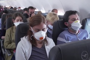 Hành khách hàng không đeo khẩu trang để ngừa Covid-19 khi đi máy bay. Ảnh: CNN.