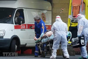 Nhân viên y tế chuyển bệnh nhân mắc COVID-19 lên xe cứu thương tại Saint Petersburg, Nga ngày 5/10/2020. (Ảnh: AFP/TTXVN).