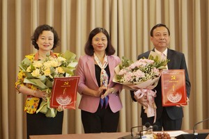 Phó Bí thư Thường trực Thành ủy Nguyễn Thị Tuyến trao Quyết định và tặng hoa chúc mừng đồng chí Trịnh Huy Thành (phải) và đồng chí Đinh Thị Lan Duyên (trái).