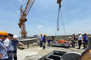 Đơn vị tháo dỡ cắt xong một ô sàn tầng 18 tòa nhà 8B Lê Trực. (Ảnh Mạnh Khánh/TTXVN).