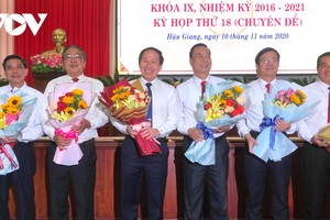 Ông Trần Văn Huyến (thứ hai từ phải qua) và ông Đồng Văn Thanh (bìa trái) nhận hoa chúc mừng.