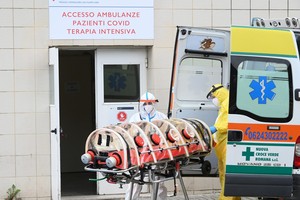 Nhân viên y tế chuyển bệnh nhân nhiễm COVID-19 tới bệnh viện ở Rome, Italy. (Ảnh: THX/TTXVN).