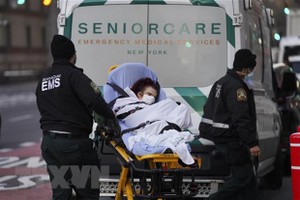 Nhân viên y tế chuyển bệnh nhân COVID-19 tới bệnh viện ở New York, Mỹ. (Ảnh: THX/TTXVN).