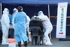 Nhân viên y tế lấy mẫu dịch xét nghiệm COVID-19 cho người dân tại Seoul, Hàn Quốc, ngày 14/12/2020. (Ảnh: THX/TTXVN).