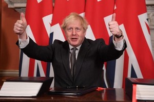 Thủ tướng Anh Boris Johnson ký thỏa thuận chính thức. Ảnh: The Guardian.
