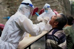 Nhân viên y tế lấy mẫu xét nghiệm Covid-19 (Ảnh: Reuters)