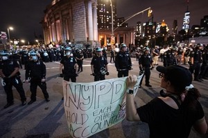 Người biểu tình đối mặt lực lượng an ninh ở New York trong thời gian áp lệnh giới nghiêm tối 2/6. Ảnh: Reuters.