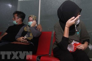 Thân nhân của các hành khách trên máy bay mang số hiệu SJ182 của hãng hàng không Sriwijaya Air chờ đợi tin tức về người thân sau khi chiếc máy bay bị mất liên lạc, tại sân bay Supadio ở Pontianak trên đảo Borneo, Indonesia, ngày 9/1/2021. (Ảnh: AFP/TTXVN).
