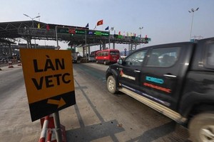 Phương tiện dán thẻ thu phí tự động không dừng đi vào làn đa được vận hành tại trạm thu phí BOT. (Ảnh: Huy Hùng/Vietnam+).