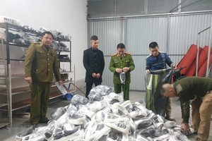 Lực lượng chức năng phát hiện thu giữ các sản phẩm quần áo, giầy dép lậu tại Hải Dương. (Ảnh: TTXVN phát).
