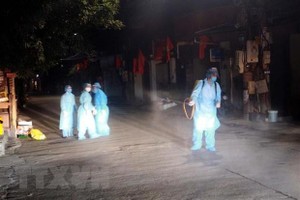 Lực lượng chức năng Quảng Ninh phun khử khuẩn khu vực bệnh nhân COVID-19 sinh sống. (Nguồn: TTXVN/phát).