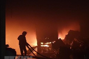 Lực lượng cứu hỏa đang khống chế ngọn lửa. (Ảnh: TTXVN phát).