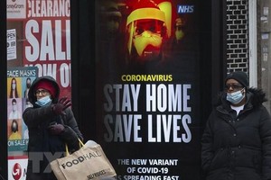 Bảng khuyến cáo người dân nên ở trong nhà để phòng lây nhiễm COVID-19 tại bến xe buýt ở London, Anh, ngày 10/1/2021. (Ảnh: THX/TTXVN).