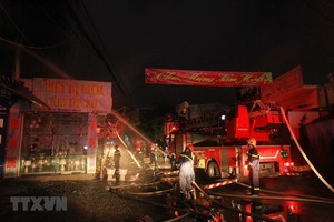 Lực lượng phòng cháy chữa cháy đang tích cực phun nước dập lửa, khống chế đám cháy. (Ảnh: An Đăng/TTXVN).