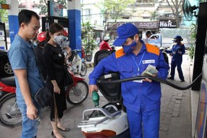 Nhân viên Petrolimex đang bán xăng cho khách hàng. (Ảnh: Đức Duy/Vietnam+).