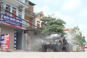 Lực lượng quân đội tiến hành phun khử khuẩn đường phố thị xã Mỹ Hào. (Ảnh: Đinh Tuấn/TTXVN).