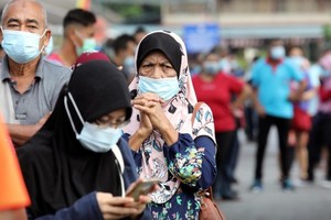 Người dân xếp hàng chờ làm xét nghiệm tại TP Klang, Malaysia, tháng 12/2020. (Ảnh: Reuters).