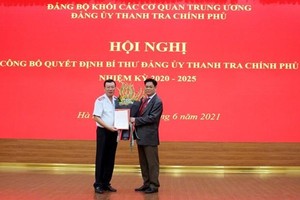 Bí thư Đảng ủy Khối các cơ quan Trung ương Huỳnh Tấn Việt trao quyết định và tặng hoa tân Bí thư Đảng ủy Thanh tra Chính phủ Đoàn Hồng Phong (trái). (Nguồn: thanhtra.com.vn).