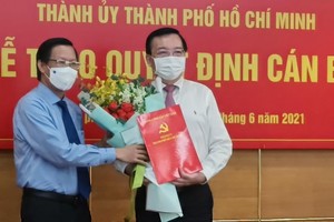 Phó Bí thư thường trực Thành uỷ Phan Văn Mãi (trái) trao quyết định cho ông Lê Hồng Sơn. (Ảnh: Quyết Thắng)