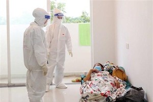 Bác sỹ Bệnh viện dã chiến thu dung, điều trị COVID-19 số 3 (thành phố Thủ Đức) thăm khám cho bệnh nhân mắc COVID-19 không triệu chứng. (Ảnh: Xuân Khu/TTXVN).