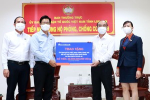 Đại diện Sacombank - ông Trần Minh Tâm, Giám đốc Chi nhánh Long An (bên trái), trao tặng 30 tỷ đồng cho Ủy ban Mặt trận Tổ quốc VN tại Long An để hỗ trợ người dân khó khăn do Covid-19.
