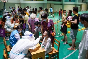 Các nhân viên y tế lấy mẫu xét nghiệm cho người dân tại thành phố Nam Kinh, tỉnh Giang Tô ngày 21/7/2021. Ảnh: Tân Hoa xã.