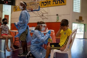 Các nhân viên y tế xét nghiệm Covid-19 cho các em nhỏ ở Binyamina, Israel. Ảnh: AP.