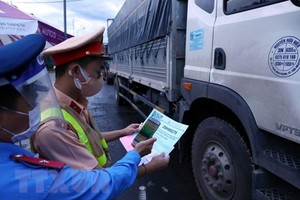 Lực lượng chức năng quét mã QR code trên điện thoại thông minh đối với phương tiện giao thông vào Hà Nội qua chốt kiểm soát dịch huyện Chương Mỹ. (Ảnh: Phạm Kiên/TTXVN).