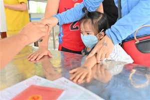 Tất cả người dân khi qua chốt kiểm soát vào Quảng Ninh phải được đóng dấu "chung tay phòng, chống dịch COVID-19." (Ảnh: TTXVN).