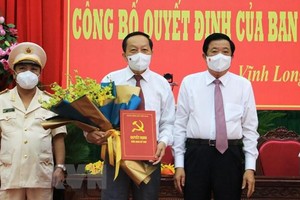 Bí thư Tỉnh ủy Vĩnh Long Bùi Văn Nghiêm trao Quyết định và tặng hoa chúc mừng ông Nguyễn Thành Thế. (Ảnh: Phạm Minh Tuấn/TTXVN).