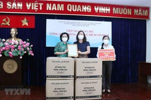 Bà Tô Thị Bích Châu (trái), Chủ tịch Ủy ban MTTQ Việt Nam Thành phố trao thư cảm ơn Hiệp hội Dệt May Việt Nam tại Thành phố Hồ Chí Minh cho bà Nguyễn Bảo Trân, Phó Chủ tịch Hiệp hội Dệt may Việt Nam. (Ảnh: Xuân Khu/TTXVN).