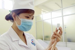 Chuẩn bị lấy vaccine phòng COVID-19 trước khi tiêm. (Ảnh: Hoàng Hùng/TTXVN).