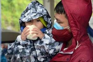 Người về quê tranh thủ nghỉ chân, ăn đồ ăn miễn phí trước khi tiếp tục lên đường. (Ảnh: Quốc Dũng/TTXVN).