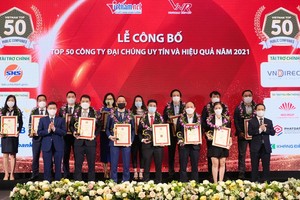 Đại diện Vietcombank (thứ 4 từ phải sang, hàng sau) và các đơn vị trong Top 50 công ty đại chúng uy tín và hiệu quả năm 2021 nhận vinh danh từ Ban tổ chức chương trình.